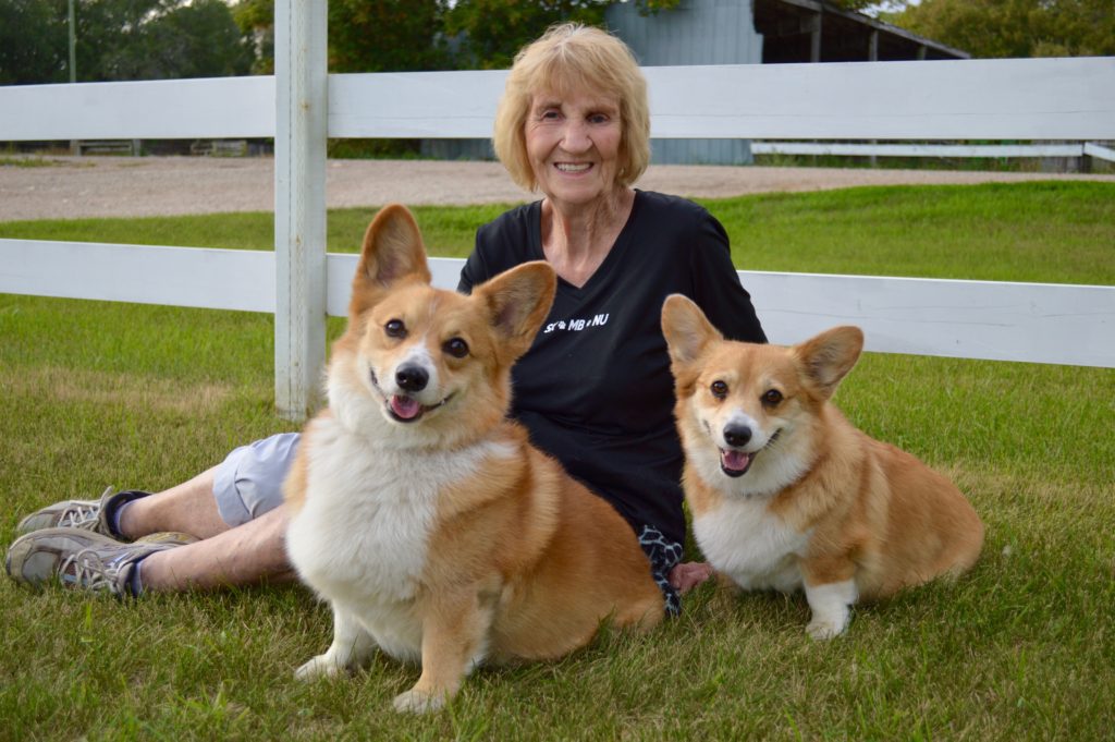 Lady with two happy corgies